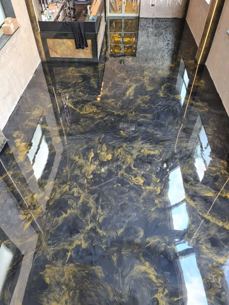 Gold and black metallic epoxy floor showing three-dimensional depth and light-reactive mica pigment movement